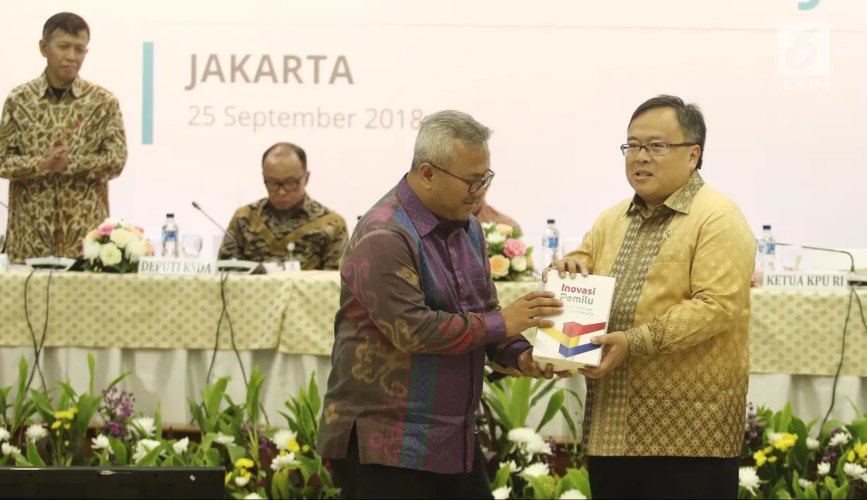 Ketua KPU Arief Budiman memberikan cenderamata kepada Menteri PPN/Bappenas Bambang Brodjonegoro saat Penyampaian Rancangan Teknokratik RPJMN 2020-2025 di Gedung KPU, Jakarta, Selasa (25/9). (Liputan6.com/Herman Zakharia)