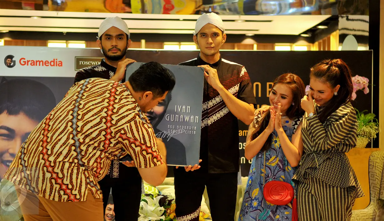 Perancang busana Ivan Gunawan secara simbolis menandatangi bukunya 'Aku Berkarya Dengan Cinta' pada acara peluncuran di Jakarta, Rabu (11/11). Ivan merilis buku untuk memperingati 10 tahun karirnya di bidang fashion. (Liputan6.com/Faisal R Syam)
