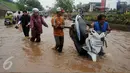Warga membantu mendorong motor yang mogok saat banjir di Jalan Raya Kalimalang, Caman, Bekasi, Senin (20/2). Akibat banjir dengan ketinggian di atas 60 cm 