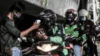 Petugas mengecek suhu tubuh pengojek daring saat pemeriksaan rutin di Posko Aman Covid-19, Jalan Ahmad Yani, Jakarta, Selasa (11/8/2020). Posko Aman Covid-19 rutin digelar untuk memeriksa kesehatan ojol guna mencegah penyebaran corona selama beroperasi di masa pandemi. (merdeka.com/Iqbal Nugroho)