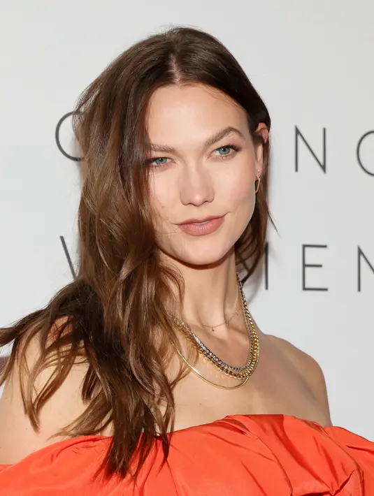 Karlie Kloss berpose saat menghadiri makan malam The Kering Foundation's Caring for Women di The Pool on Park Avenue di New York City pada 15 September 2022. Karlie Kloss tampil memukau dalam gaun oranye cerah dengan ruffles dramatis yang menggantung di bahunya. (Dia Dipasupil/Getty Images/AFP)