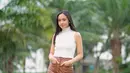 Bergaya bak model, Lyodra tampil mengenakan sleeveless turtleneck top berwarna putih yang dipadukan dengan bawahan leather pants berwarna cokelat / (instagram/lyodraofficial)