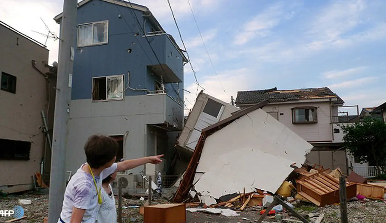 Warga Koshigaya menunjuk sebuah rumah yang rusak akibat tornado pada tanggal 2 September 2013. (AFP/Kazuhiro Nogi/wwn)