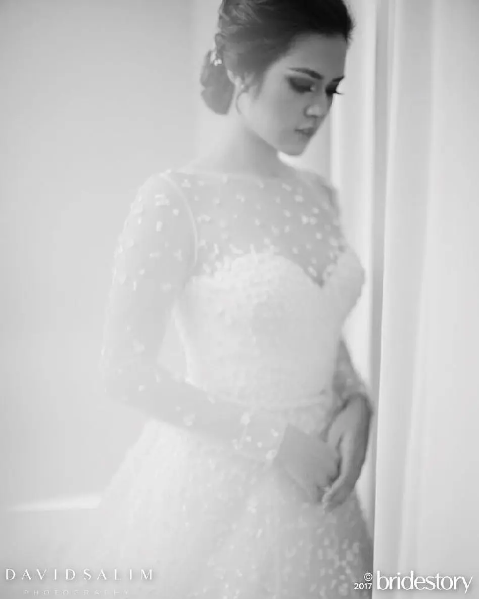 Raisa dalam balutan gaun pengantin untuk resepsi pernikahan. (Instagram - @thebridestory)
