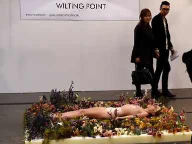 Seniman wanita, Millie Brown terlentang di atas karya seninya saat pameran berjudul 'Wilting Point' atau Titik Layu di LA Art Show, Los Angeles, Minggu (31/1). Brown akan bertahan selama 5 hari hanya meminum air. (Mark Ralston/AFP)