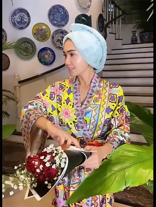 <p>Masih menempel handuk di kepalanya. Yuni memegang sebuket bunga kiriman dari Cello. Perempuan berusia 50 tahun itu tampak bahagia mendapatkan bunga. Sedangkan suratnya tertulis dari Cevin dan Cello. [Instagram/yunishara36]</p>