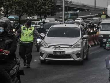 Petugas kepolisian memberhentikan mobil yang melanggar aturan ganjil genap di Jalan MT Haryono, Jakarta, Kamis (28/10/2021). Direktorat Lalu Lintas Polda Metro Jaya mulai hari ini memberlakukan sanksi tilang kepada pelanggar ganjil genap di 13 ruas jalan DKI Jakarta. (merdeka.com/Iqbal S Nugroho)