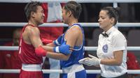 Petinju asal Indonesia Huswatun Hasanah berbincang dengan Sudaporn Seesondee asal Thailand usai babak semifinal kelas ringan (57-60 kg) Asian Games 2018 di JIExpo Kemayoran Jakarta, Jumat (31/8/2018). (Bola.com/Peksi Cahyo)
