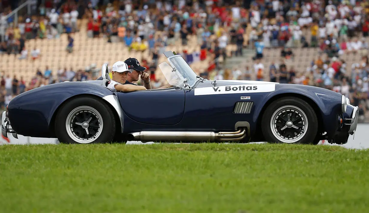 Pembalap Williams Formula Satu, Valtteri Bottas, ikut berparade mengelilingi Sirkuit Hockenheim menggunakan mobil antik, (20/7/2014). (REUTERS/Kai Pfaffenbach) 