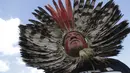 Seorang pria Pribumi mengambil bagian dalam pawai untuk memprotes usulan undang-undang yang akan mengubah kebijakan yang membatasi tanah Pribumi, di Brasilia, Brasil, Selasa, 30 Mei 2023. (AP Photo/Gustavo Moreno)