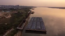 Tongkang menunggu untuk diangkut di tengah kekeringan berkelanjutan yang mempengaruhi ketinggian air sungai Paraguay di pantai tepi San Miguel, Paraguay, Senin (20/9/2021).  (AP Photo/Jorge Saenz)