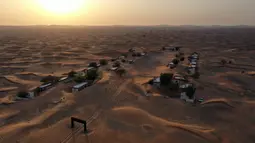 Pemandangan dari udara menunjukkan desa Al-Madam yang ditinggalkan, berbatasan dengan Emirat Teluk Sharjah, setengah terkubur di pasir gurun, Kamis (22/4/2021). Tanpa alasan yang jelas, desa tersebut ditinggalkan penduduknya begitu saja yang membuatnya kini bak kota hantu. (GIUSEPPE CACACE/AFP)
