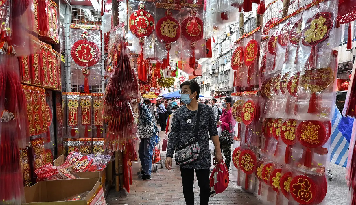 Seorang pria berbelanja dekorasi menjelang Tahun Baru Imlek di Hong Kong pada 26 Januari 2022. Tahun Baru Imlek untuk masyarakat Tionghoa atau China di seluruh dunia pada tahun ini akan jatuh pada tanggal 1 Februari 2022. (Peter PARKS / AFP)
