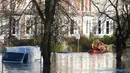 Tim regu penyelamat menyisir lokasi pemukiman warga yang terendam banjir menggunakan perahu karet di York, Inggris utara, Minggu (27/12). Banjir akibat luapan sungai Ouse yang telah memperburuk sejumlah wilayah Inggris utara. (REUTERS/Phil Noble)