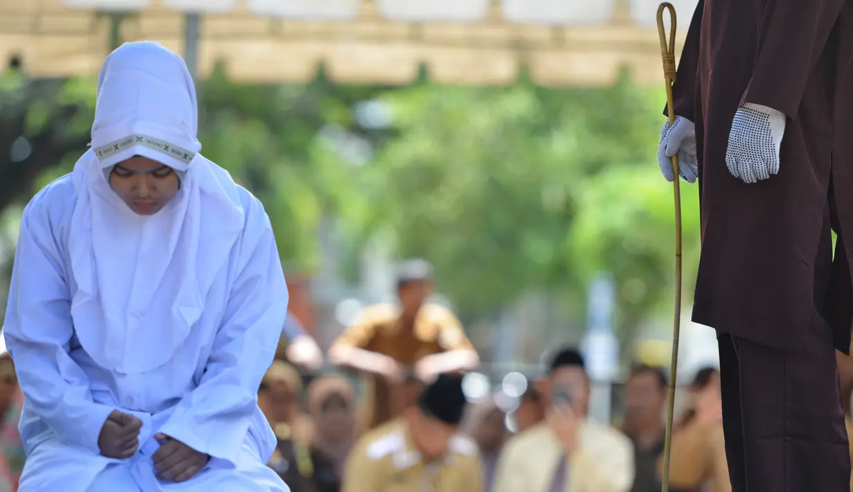 Seorang karyawati bernama Nur Fadilah (21) bersiap jelang dihukum cambuk karena mesum di Banda Aceh, Senin (29/10). Nur dan pasangannya terbukti melakukan ikhtilat (bercumbu). (Chaideer Mahyuddin/AFP)