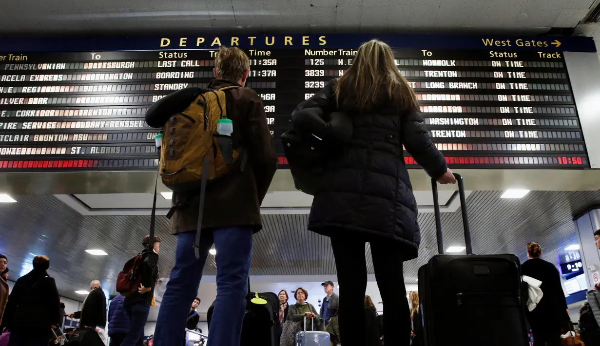 Wisatawan melihat papan jadwal perjalanan di Pennsylvania Station, New York City, Rabu (23/11). Di Amerika Serikat, tradisi mudik dilakukan saat hari perayaan Thanksgiving yang jatuh setiap Kamis keempat di November. (REUTERS/Brendan McDermid)