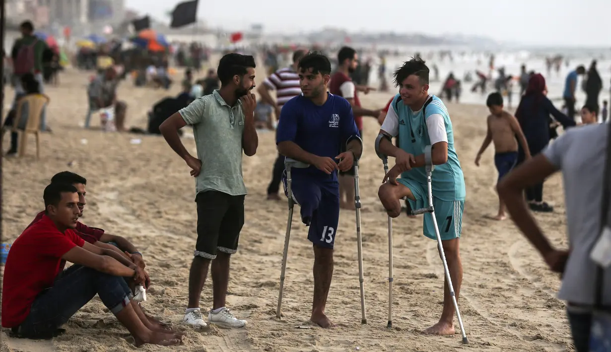 Dua pemuda Palestina Mohammed Eliwa dan Ahmed al-Khoudari berbincang usai bermain sepak bola di pantai di Kota Gaza (20/9/2019). Eliwa 17 tahun dan Ahmed al-Khoudari 20 tahun kehilangan satu kakinya saat bentrok di perbatasan Israel. (AFP Photo/Mahmud Hams)