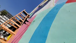 Tarsila Schubert menggunakan tangga membuat karya mural di dinding Museum Seni Terbuka, Kota Amman, Yordania, Kamis (29/9). Mural karya Tarsila Schubert asal Brasil itu menghiasi Museum Seni Terbuka, Kota Amman, Yordania. (REUTERS/Muhammad Hamed)