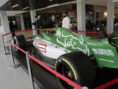 Seorang pria melihat mobil balap di pusat tiket gelaran Formula One (F1), di Jeddah, Arab Saudi, Selasa (30/11/2021). Arab Saudi untuk pertama kalinya dipercaya menjadi tuan rumah balapan F1 2021, yang akan berlangsung 3-5 Desember mendatang. (AP Photo/Amr Nabil)