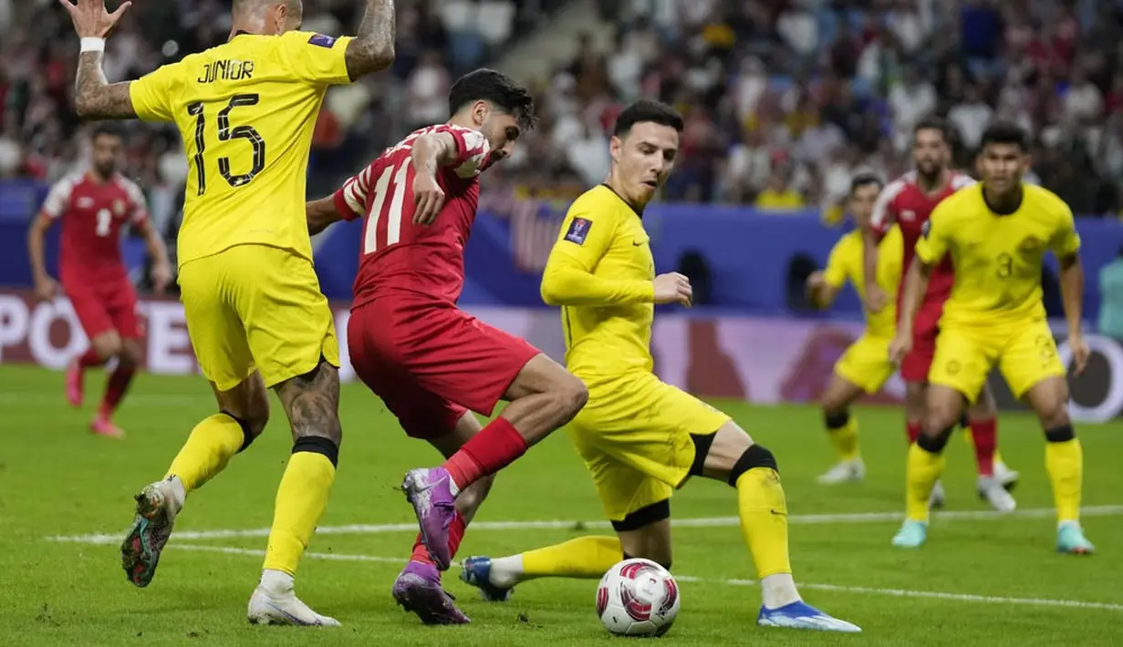 Pemain Yordania, Yazan Alnaimat, berusaha melewati pemain Malaysia, Dion Cools, dalam laga Grup E Piala Asia 2023 yang digelar di Al Janoub Stadium, Al Wakrah, Selasa (16/1/2024). (AP Photo/Aijaz Rahi)
