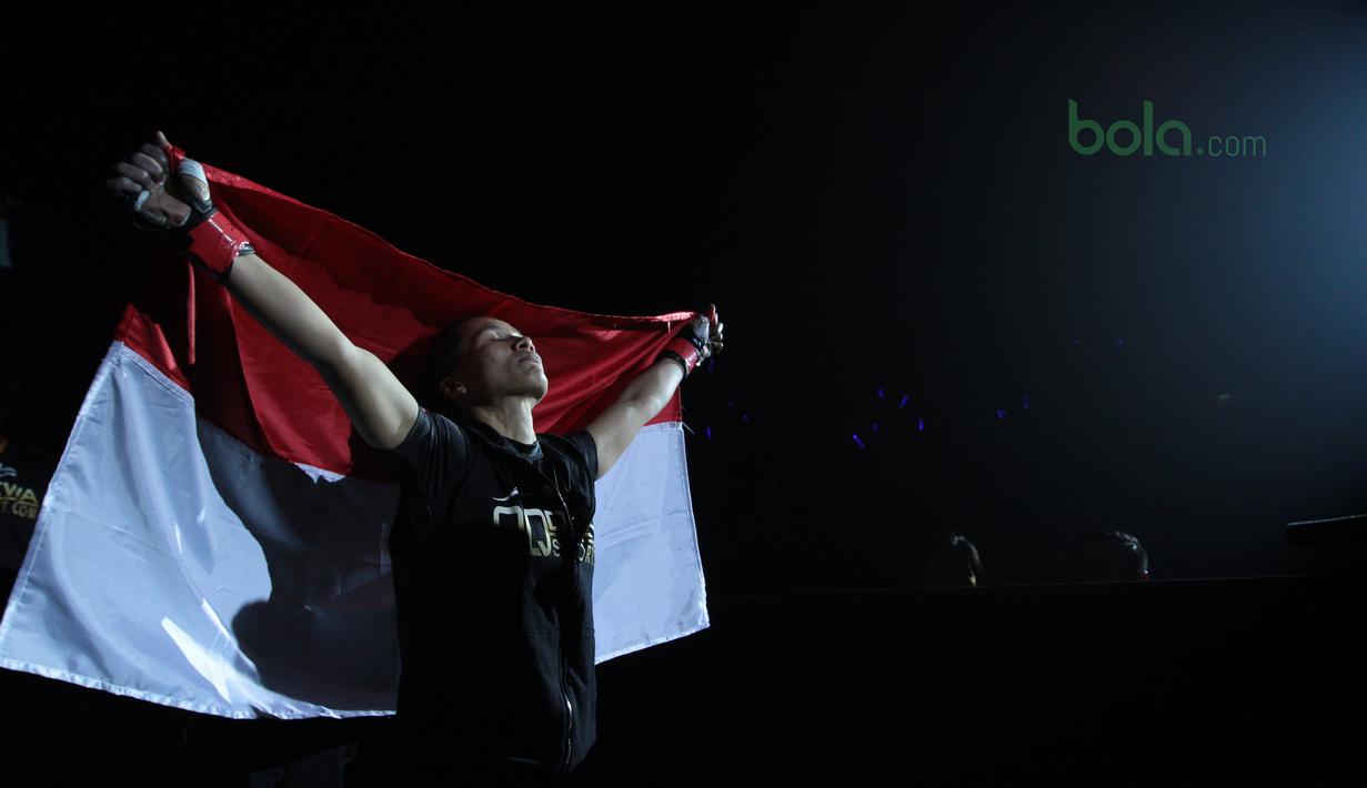 Ekspresi Priscilla Lumban Gaol dengan bendera Merah-Putih saat melawan petarung Filipina, Rome Trinidad pada ajang One Championship 2018 di Jakarta Convention Center, Sabtu (12/5/2018). Priscilla menang padan ronde pertama. (Bola.com/Nick Hanoatubun)