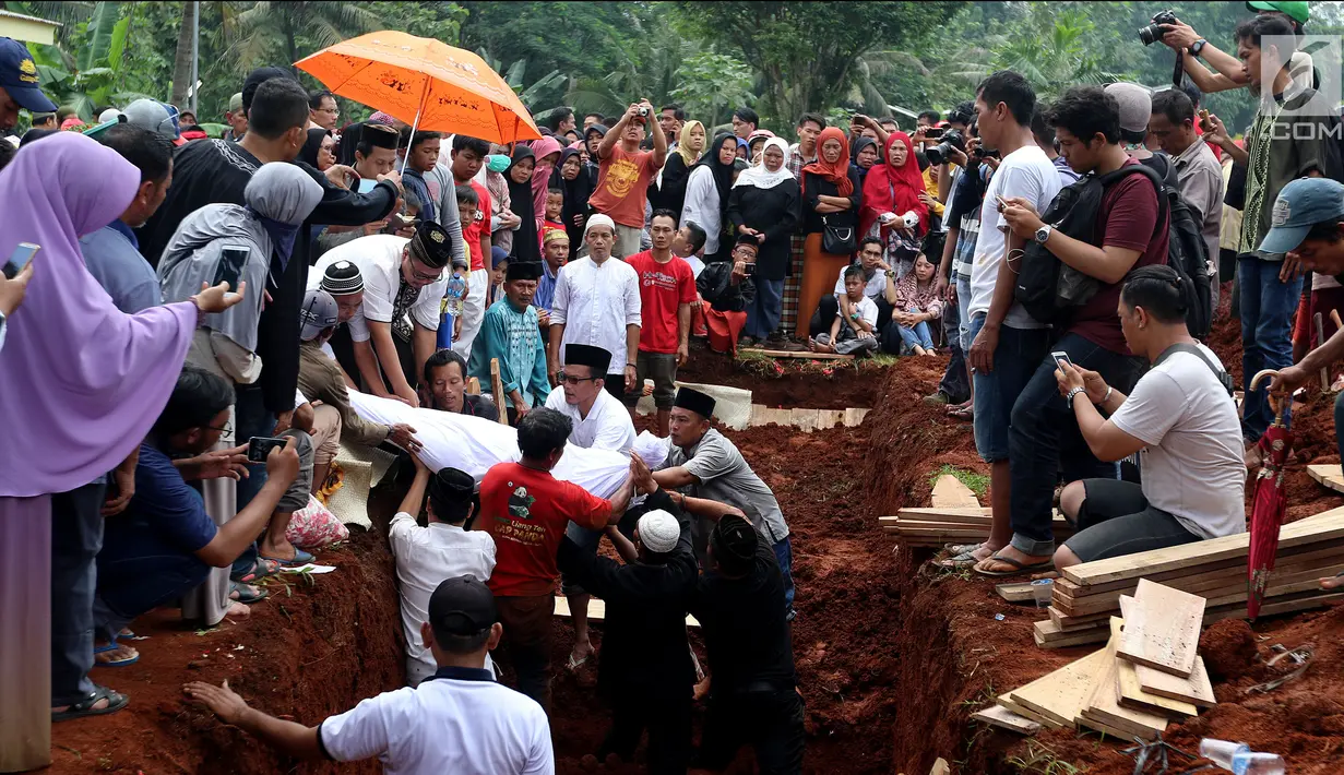 Proses penguburan massal korban kecelakaan bus di Tanjakan Emen Subang di TPU Legoso Ciputat, Tangerang Selatan, Banten, Minggu (11/2). Sebanyak 26 korban dimakamkan di TPU Legoso ini. (Liputan6.com/JohanTallo)