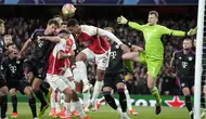 Bek Arsenal, William Saliba (tengah) berduel udara dengan gelandang Bayern Munchen, Leon Goretzka dalam sebuah kemelut di depan gawang Bayern Munchen pada laga leg pertama babak perempatfinal Liga Champions 2023/2024 di Emirates Stadium, London, Selasa (9/4/2024) malam. (AP Photo/Frank Augstein)