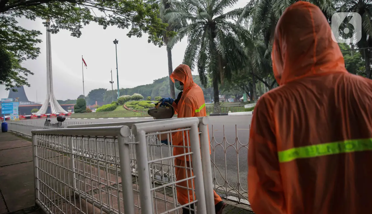 Petugas menyemprotkan cairan disinfektan di TMII, Jakarta, Rabu (18/3/2020). Penyemprotan dilakukan untuk mengantisipasi penyebaran virus corona COVID-19. (Liputan6.com/Faizal Fanani)