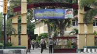 Sejumlah personel provost Propam Polda Sulteng berjaga di gerbang masuk Mapolda Sulteng saat digelar acara di halaman Mapolda Sulteng, Jumat (26/6/2020). (Foto: Liputan6.com/ Heri Susanto).