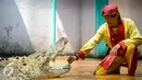 Seorang pawang buaya  memasukan daun sirih ke dalam mulut buaya saat melakukan atraksi di Taman Wisata Buaya, Cibarusah, Jawa Barat, Minggu (26/7/2015). Atraksi berlangsung pada hari Minggu mulai dari pukul 11:00 dan 14:00. (Liputan6.com/Faizal Fanani)