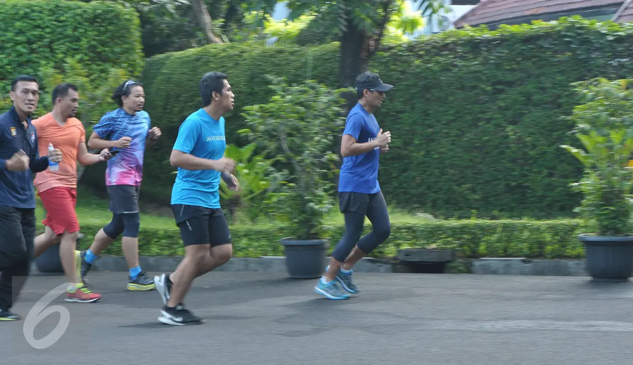 Calon wakil gubernur nomor urut 3, Sandiaga Uno lari ditemani anggota komunitas Jakarta Berlari dan para relawan mengelilingi tempat pemungutan suara (TPS) di sekitar rumahnya di Selong, Kebayoran Baru, Jakarta, Rabu (19/4). (Liputan6.com/Helmi Afandi)