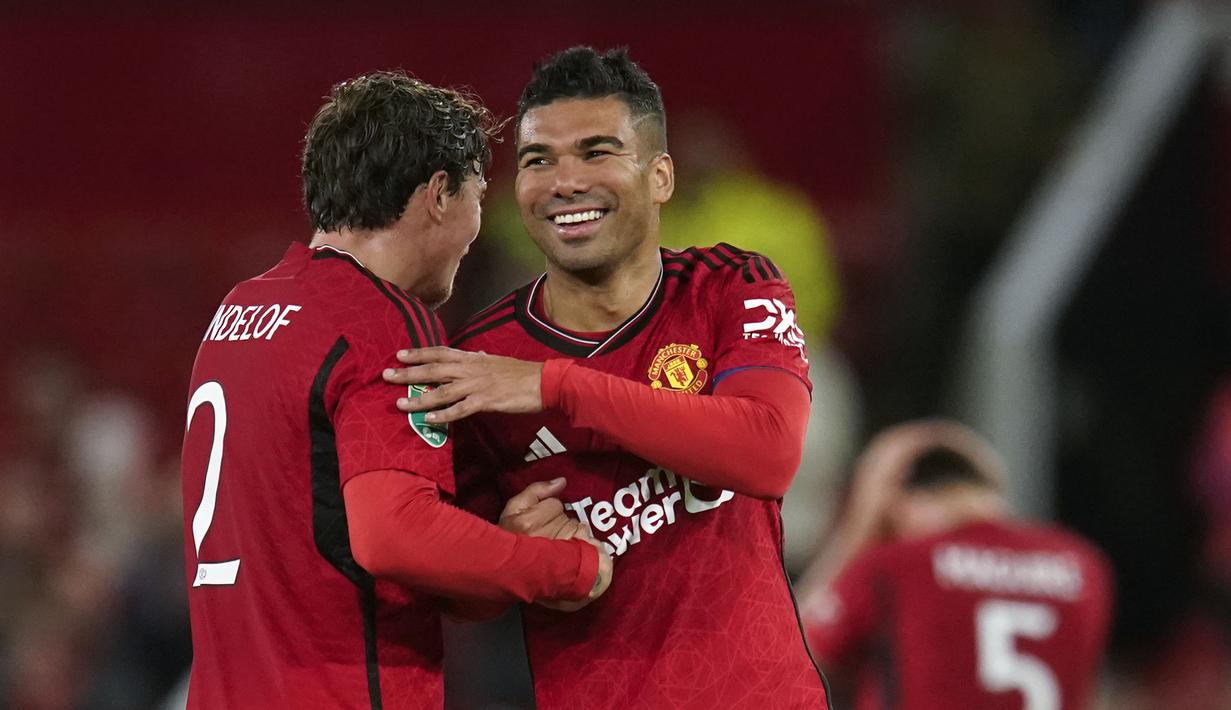 Pemain Manchester United, Casemiro merayakan kemenangan bersama rekannya, Victor Lindelof setelah mengalahkan Crystal Palace pada laga putaran ketiga Carabao Cup 2023/2024 di Old Trafford, Manchester, Inggris, Rabu (27/09/2023). Kemenangan 3-0 MU membawa mereka melaju ke putaran keempat alias babak 16 besar. (AP Photo/Dave Thompson)