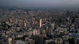 Gambar yang diambil pada 11 Oktober 2021 ini menunjukkan pemandangan udara matahari terbenam di ibu kota Lebanon, Beirut, dengan gedung-gedung dalam kegelapan selama pemadaman listrik. Selama 18 bulan terakhir, Lebanon telah mengalami krisis ekonomi dan kekurangan bahan bakar ekstrem. (AFP)