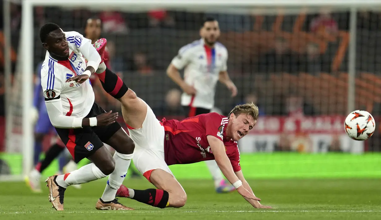 Pemain Manchester United, Rasmus Hojlund berebut bola dengan pemain Lyon, Moussa Niakhate dalam laga lanjutan Liga Europa 2024/2025 di Old Trafford, Manchester, Inggris, Jumat (18/04/2025) dini hari WIB. (AP Photo/Jon Super)