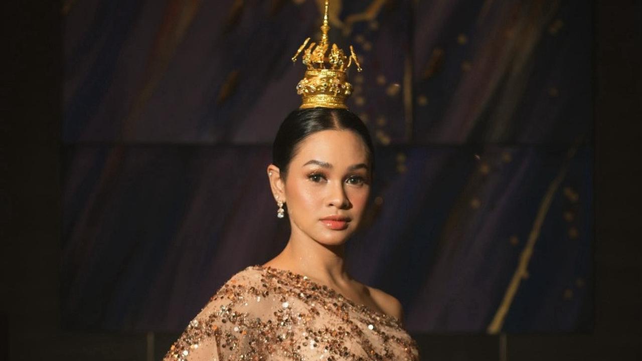Tampilan Andien semakin memukau dengan kombinasi gaun sequin berwarna bronze dan hiasan kepala Thailand yang glamor.<br><br>