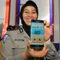 Petugas Kakorlantas Polri memperlihatkan aplikasi SIM Online saat launching di Jakarta, Jumat (16/12). Dalam rangka meminimalisir pungli, Korlantas merilis 3 aplikasi mulai dari SIM online, e-Tilang, hingga e-Samsat. (Liputan6.com/Angga Yuniar)