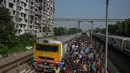 Komuter memadati peron kereta api di Kolkata, India, Senin (1/11/2021). Layanan kereta api kembali normal setelah menerapkan pembatasan yang diberlakukan sebelumnya untuk mengekang penyebaran corona Covid-19. (DIBYANGSHU SARKAR/AFP)