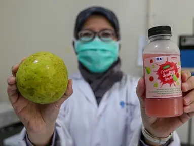 Peneliti menunjukkan buah jambu merah dan minuman jambu merah yang telah difermentasi di Kimia Pangan Pusat Penilitian Kimia LIPI Puspitek, Serpong, Tangerang, Kamis (4/6/2020). Proses fermentasi selama 2-7 hari cocok diminum yang imunitas rendah di masa pandemi Covid-19. (Liputan6.com/Fery Pradolo)