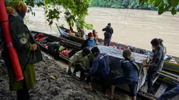 Foto yang diambil pada 20 Juni 2020 memperlihatkan petugas Balai Konservasi Sumber Daya Alam (BKSDA) Aceh memindahkan kerangkeng berisi Harimau Sumatra liar sebelum proses pelepasliaran di kawasan Taman Nasional Gunung Leuser (TNGL), Aceh. (CHAIDEER MAHYUDDIN / AFP)