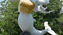 Patung putri duyung yang bagian dadanya ditutup kain berwarna emas di kawasan Putri Duyung Resort Ancol, Jakarta, Selasa (26/3). Alasan pemakaian kemben pada para patung putri duyung tersebut adalah untuk menyesuaikan dengan budaya ketimuran. (Photo by ADEK BERRY / AFP)