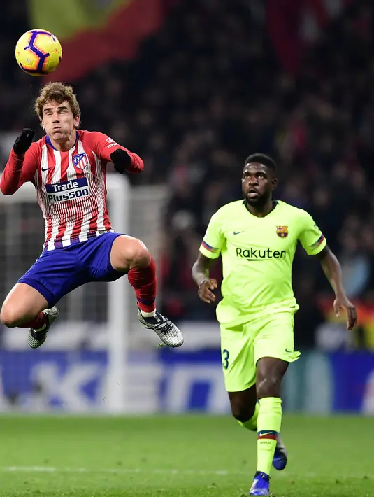 Striker Atletico Madrid, Antoine Griezmann berusaha mengontrol bola dari kawalan bek Barcelona, Samuel Umtiti selama pertandingan Liga Spanyol di stadion Wanda Metropolitano di Madrid (24/11/2018). Griezmann sesungguhnya masih memiliki kontrak sampai 2023 bersama Atletico. (AFP Photo/Javier Soriano)