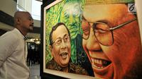 Pengunjung melihat lukisan dalam pameran seni rupa "Sang Maha Guru" karya pelukis Nabila Dewi Gayatri di Jakarta, Kamis (22/11). Lukisan Gus Dur dipadu dengan berbagai tokoh dan ragam dimensi. (Merdeka.com/Iqbal Nugroho)