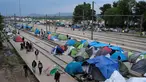 Sejumlah imigran saat membuka tenda di sebuah stasiun kereta api di sebuah kamp darurat bagi para migran dan pengungsi di perbatasan Yunani-Macedonia dekat desa Idomeni, Yunani, 10 Mei 2016. (REUTERS / Marko Djurica)