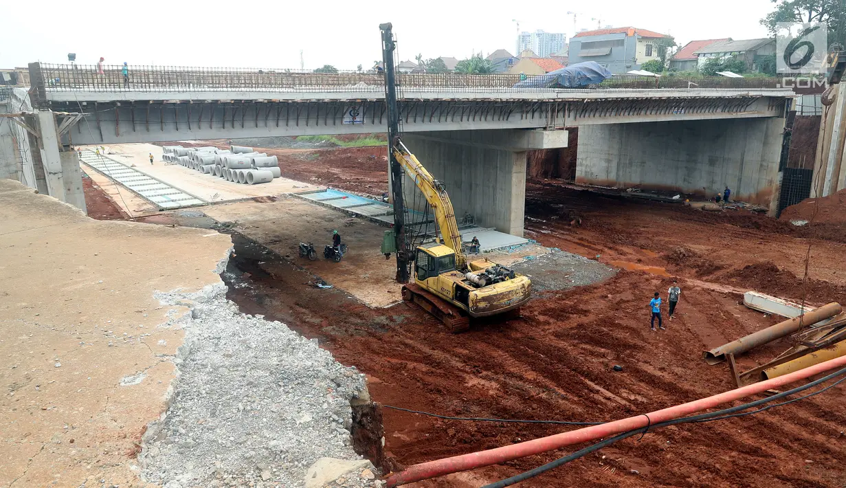 Pekerja menurunkan alat berat untuk menyelesaikan pembangunan proyek Tol Depok - Antasari (Desari) di TB Simatupang, Jakarta, Rabu (11/8). (Liputan6.com/JohanTallo)
