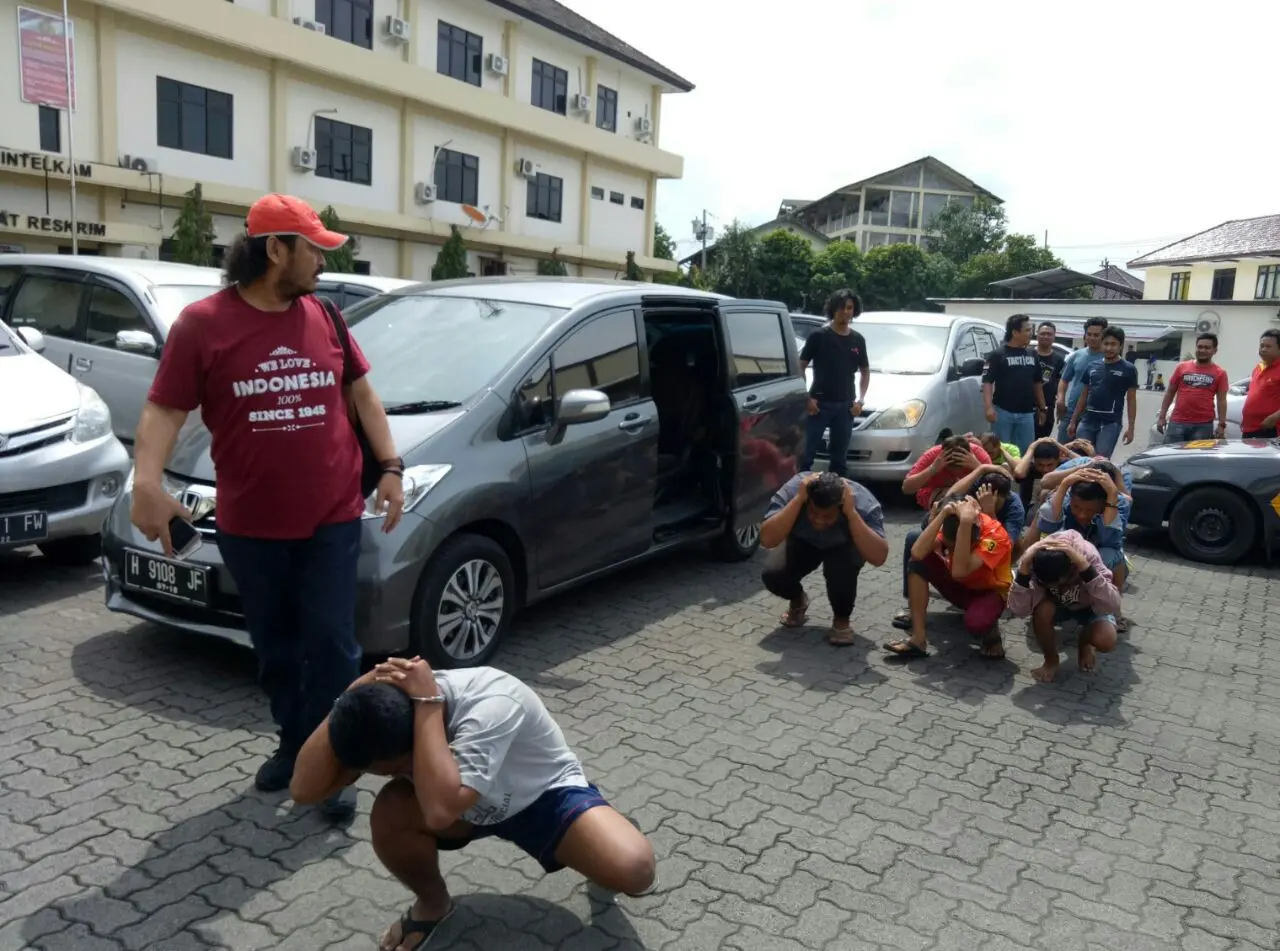 Anggota geng motor Camp TT diminta berbaris dan berjalan jongkok menuju ruang pemeriksaan. (foto: Liputan6.com/edhie prayitno ige)