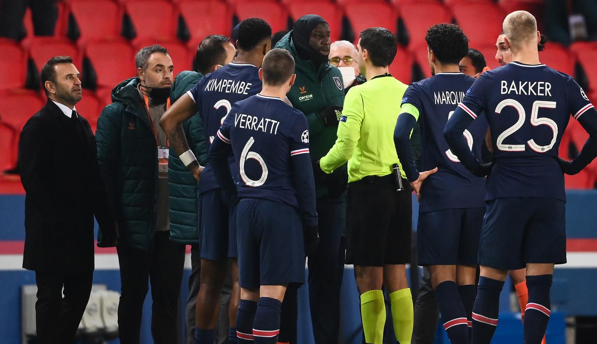 Gelandang Istanbul Basaksehir, Demba Ba (tengah), berbicara dengan wasit Ovidiu Hategan, usai dihentikannya laga lanjutan Liga Champions Grup H melawan Paris Saint-Germain di Parc des Princes Stadium, Selasa (8/12/2020). (AFP/Franck Fife)