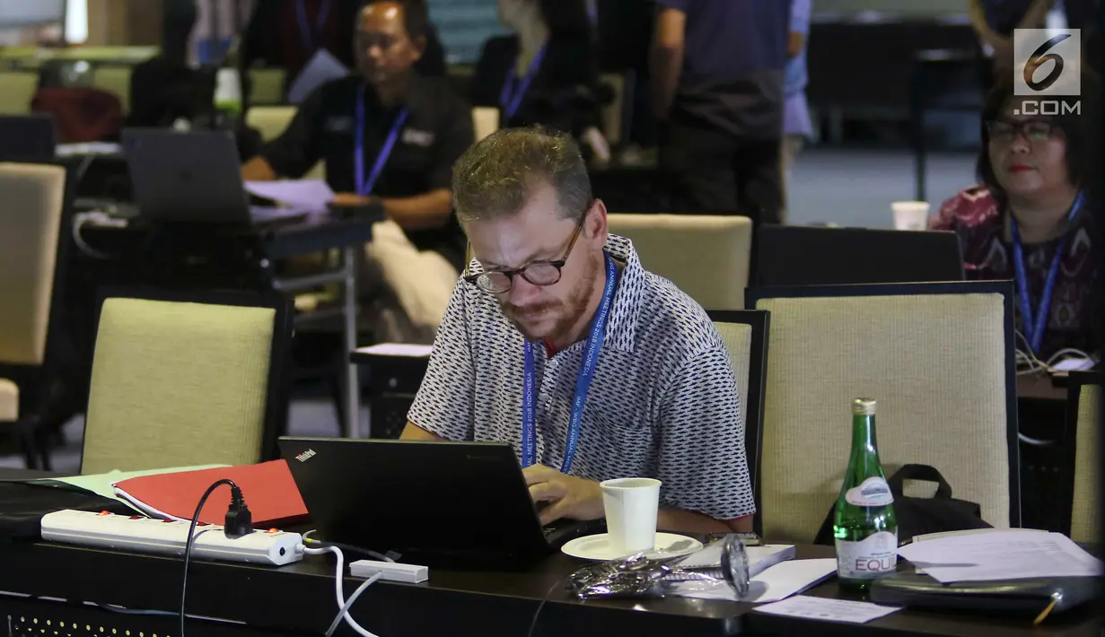 Seorang jurnalis mengetik berita pertemuan tahunan IMF-Bank Dunia di Nusa Dua, Bali, Senin (8/10). Menkominfo Rudiantara memastikan fasilitas internet kencang untuk tamu dan media dalam pertemuan tahunan ini. Liputan6.com/Angga Yuniar)