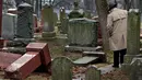 Warga melihat batu nisan Yahudi yang rusak usai serangan vandalisme di Chesed Shel Emeth Cemetery di University City, St Louis, Missouri, (21/2). Setidaknya lebih dari 100 batu nisan rusak di pekuburan itu. (Robert Cohen /St. Louis Post-Dispatch via AP)