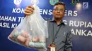 Petugas menunjukkan kantong plastik berisi residu atau sisa uang palsu yang sudah dihancurkan di Gedung Bank Indonesia (BI), Rabu (26/7). BI memusnahkan 189.477 uang rupiah palsu yang ditemukan sejak 2014 hingga akhir 2016 (Liputan6.com/Immanuel Antonius)