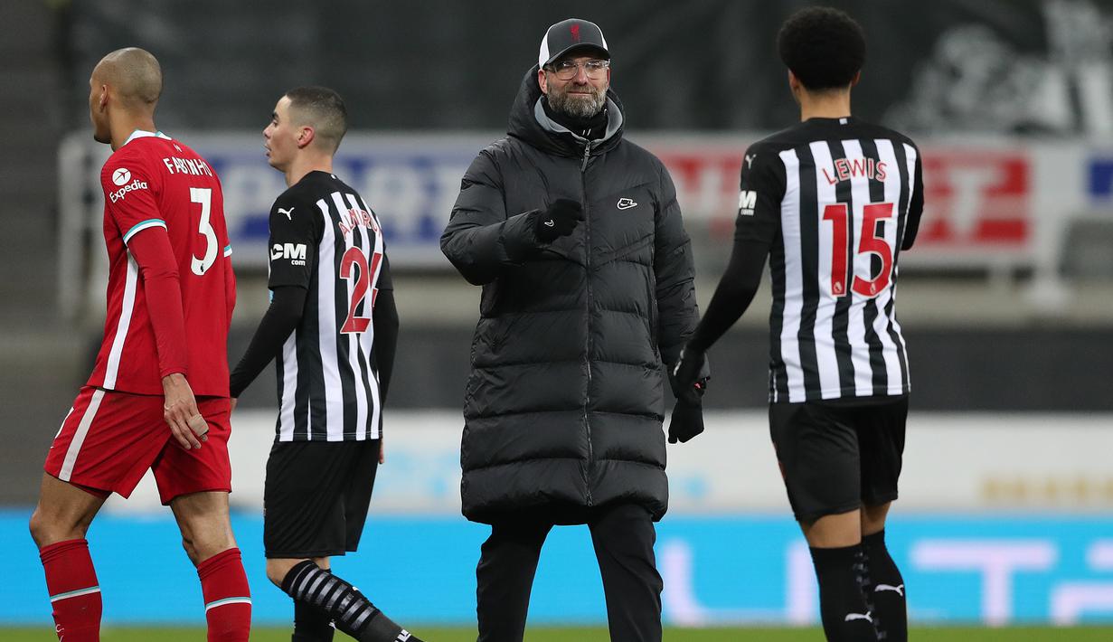 Manajer tim Liverpool, Jurgen Klopp menghampiri bek Newcastle United, Jamal Lewis untuk berjabat tangan usai berakhirnya laga lanjutan Liga Inggris 2020/21 pekan ke-16 di St James' Park, Rabu (30/12/2020). Liverpool bermain imbang 0-0 dengan Newcastle United. (AFP/Scott Heppell/Pool)